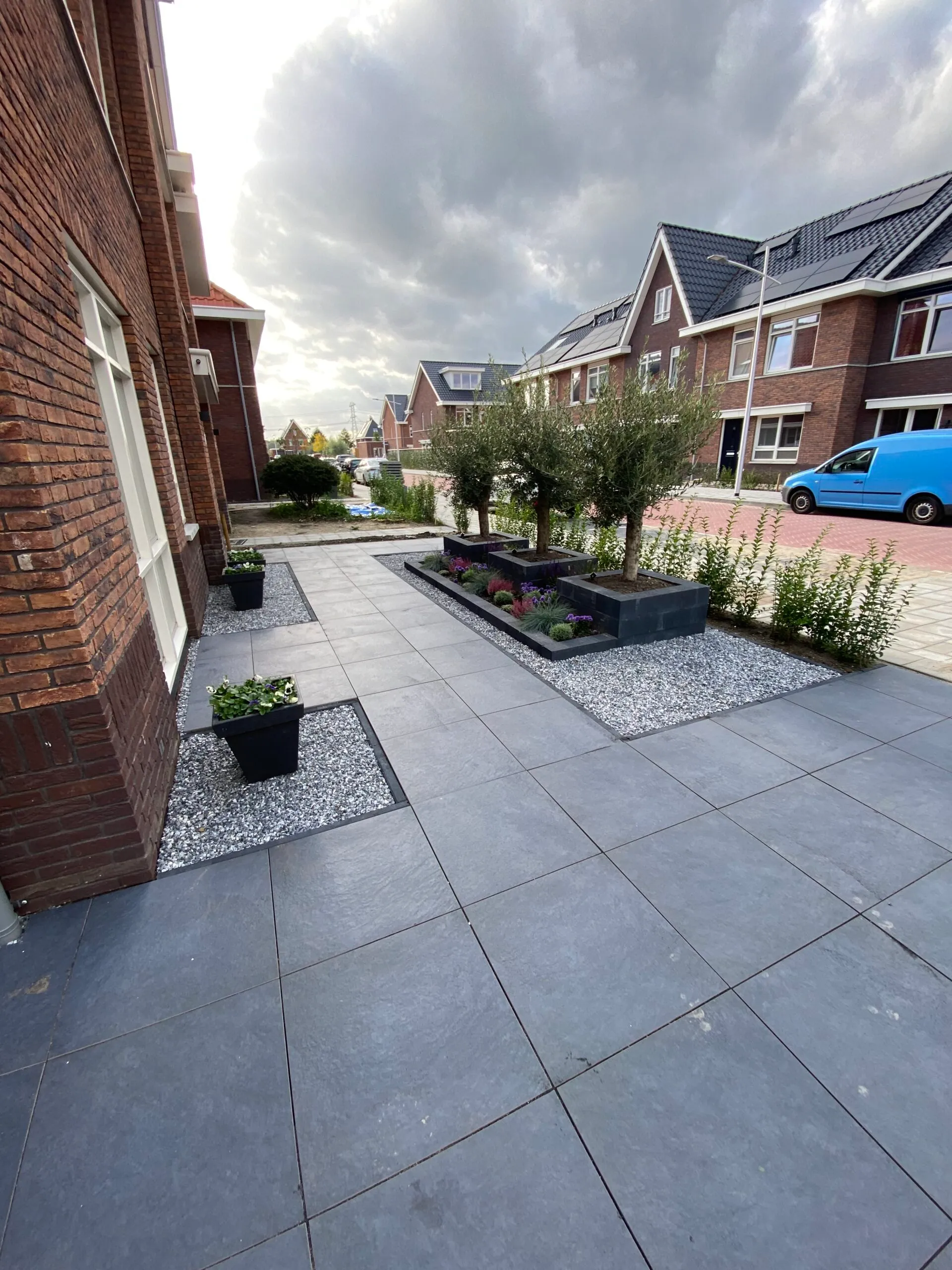 Moderne voortuin met grote grijze tegels