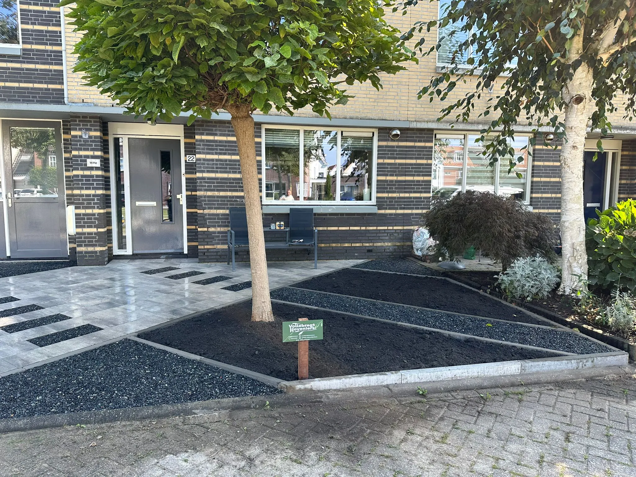 Voortuin met boom en donkere split
